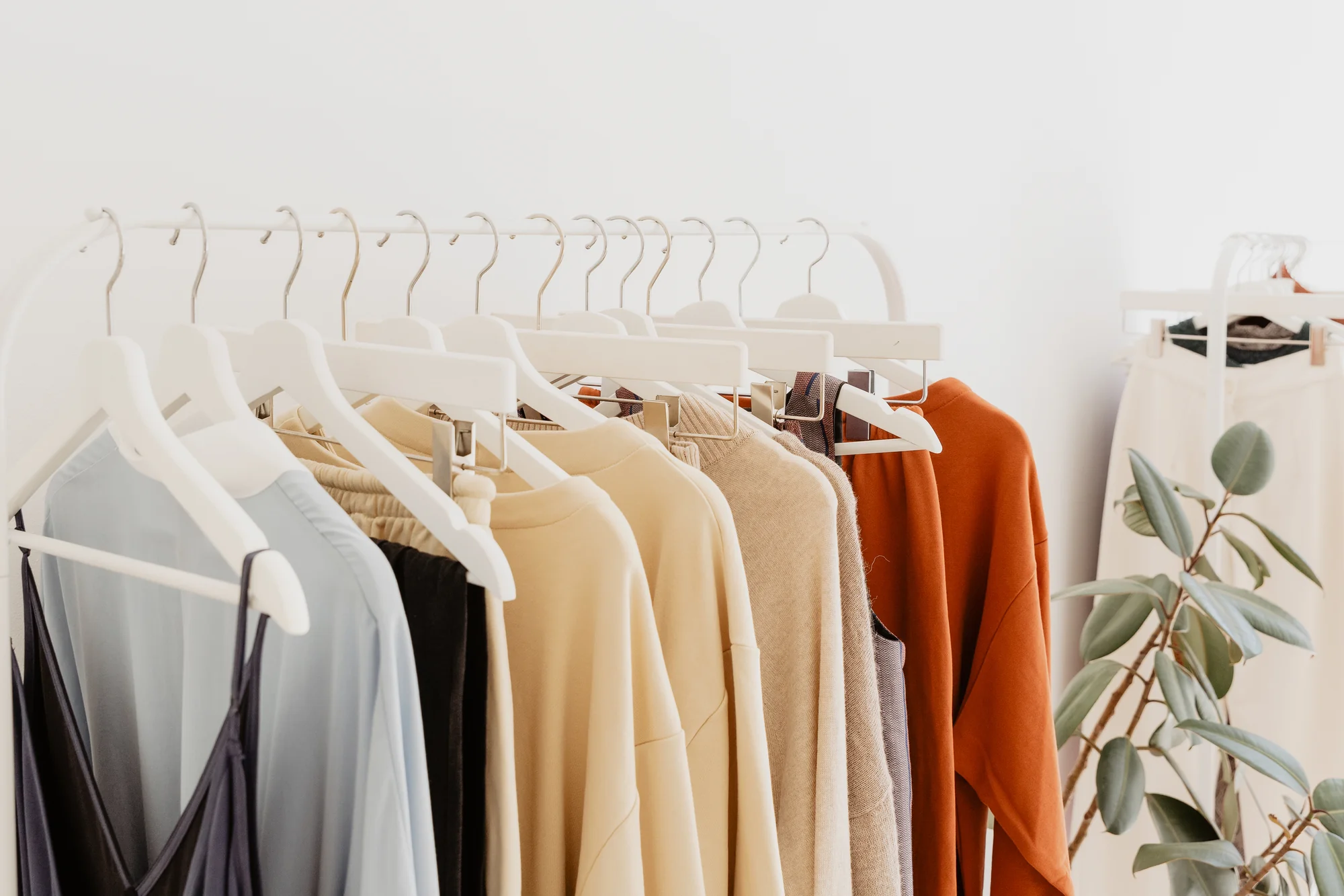Clothing on hangers in soft, neutral tones